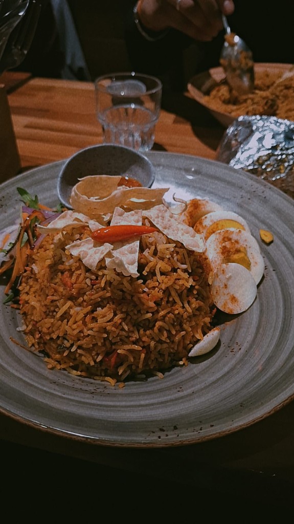Shared meal at the first HealthCrew AI team dinner — seasoned rice with egg, salad, and papadum